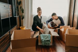 couple moving boxes from apartment