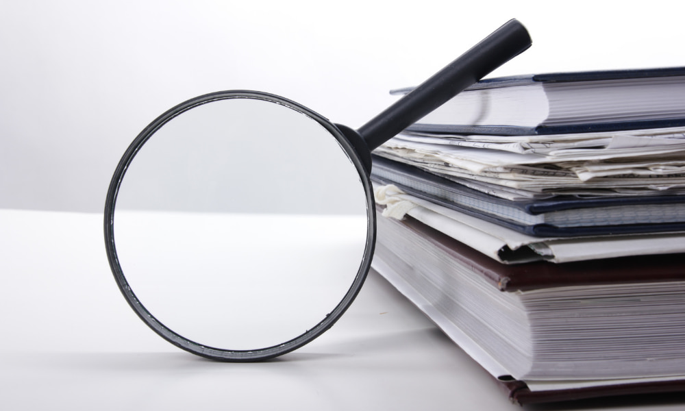 magnifying glass over a stack of documents